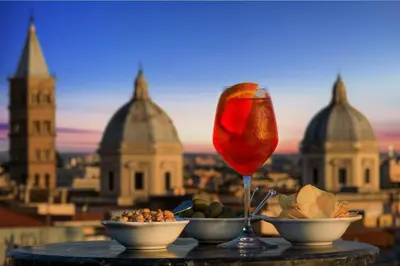 a table with a glass of wine and bowls of food at Golden Tulip Rome Piram in Rome