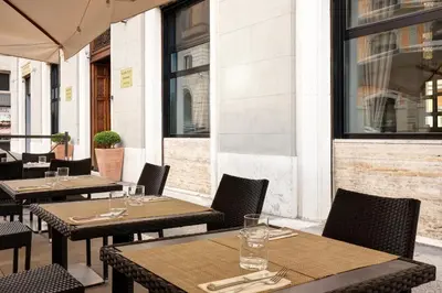 a row of tables and chairs on a patio at Golden Tulip Rome Piram in Rome