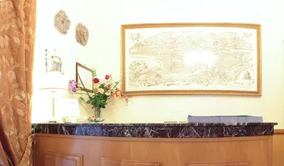 a picture on a wall with a vase of flowers on a counter at Hotel Euro Quiris in Rome