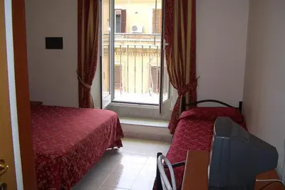 a hotel room with two beds and a window at Hotel Euro Quiris in Rome