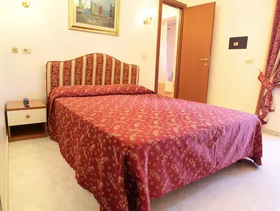 a bedroom with a bed with a red comforter at Hotel Euro Quiris in Rome