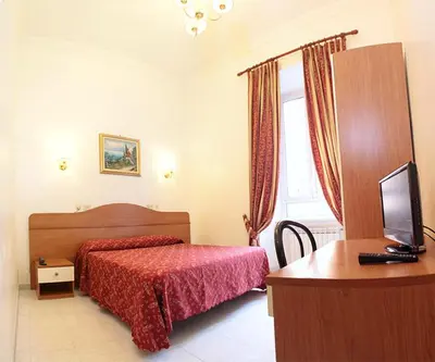 a bedroom with a bed and a desk with a computer at Hotel Euro Quiris in Rome