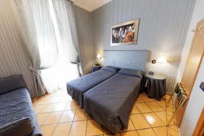 a small bedroom with a bed and a couch at Hotel Lirico in Rome