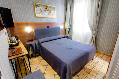 a small bedroom with a bed and a window at Hotel Lirico in Rome