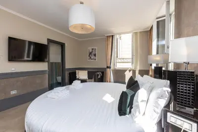 a bedroom with a large bed with white sheets and pillows at Hotel Castellino Roma in Rome