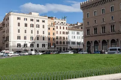 a field of grass in a city with buildings at Hotel Castellino Roma in Rome