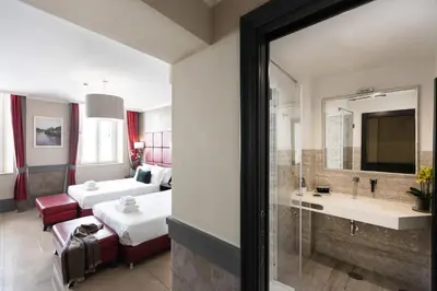 a hotel room with a bed and a bathroom at Hotel Castellino Roma in Rome
