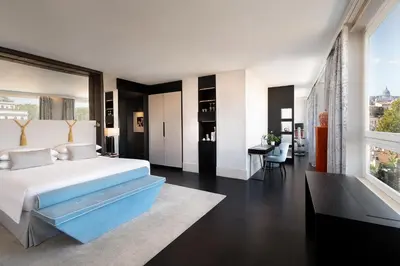 a bedroom with a large bed and a dining room at Sina Bernini Bristol, Autograph Collection in Rome