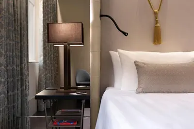 a hotel room with a bed and a table with a lamp at Sina Bernini Bristol, Autograph Collection in Rome