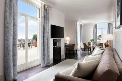 a living room with a couch and a large window at Sina Bernini Bristol, Autograph Collection in Rome