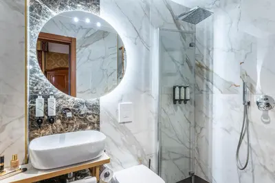 a bathroom with a shower and a sink and a mirror at Hotel Raffaello - Sure Hotel Collection by Best Western in Rome