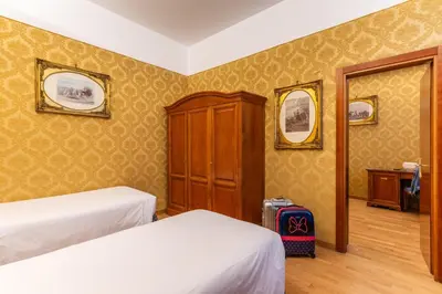 a hotel room with two beds and a cabinet at Hotel Raffaello - Sure Hotel Collection by Best Western in Rome