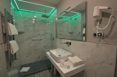 a bathroom with a sink and a shower with a mirror at Hotel Montecarlo in Rome