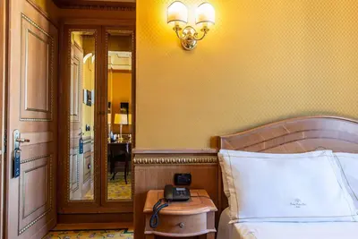 a bedroom with a bed with a phone on a table at River Palace Hotel in Rome