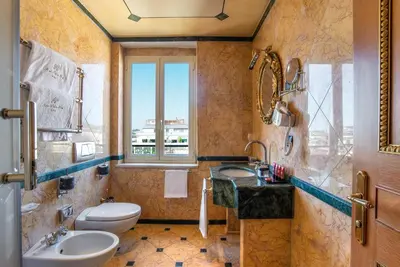 a bathroom with two sinks and a toilet and a window at River Palace Hotel in Rome