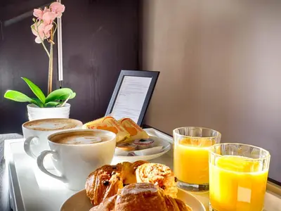 a table with a breakfast of coffee and croissants and orange juice at Sunny Guest House in Rome