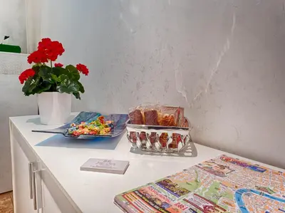 a table with a bowl of candy and a vase of flowers at Sunny Guest House in Rome