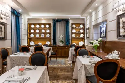 a restaurant with tables and chairs and plates on the wall at Hotel Barocco in Rome