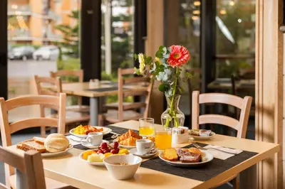 a table with breakfast foods and orange juice on it at Garner Hotel Rome Aurelia by IHG in Rome