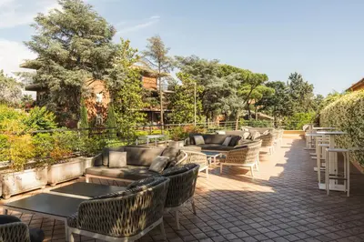 a row of couches and tables on a patio at Garner Hotel Rome Aurelia by IHG in Rome