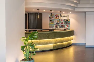 a hotel lobby with a potted plant in the foreground at Garner Hotel Rome Aurelia by IHG in Rome