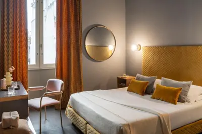 a woman sitting on a chair reading a book at Hotel Milani in Rome