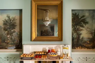 a woman holding a cup of coffee and a plate of food at Hotel Milani in Rome