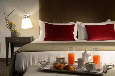 a tray of food on a bed with drinks and biscuits at Colonna Palace Hotel in Rome