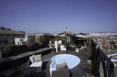 a patio with a hot tub on a balcony at Colonna Palace Hotel in Rome