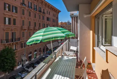 a balcony with a green and white umbrella on a building at Magenta Vaticano Fornaci in Rome
