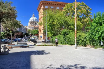 a man walking down a sidewalk in front of a building at Magenta Vaticano Fornaci in Rome