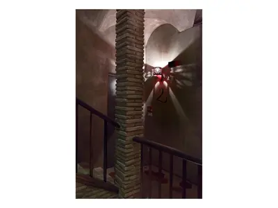 a person walking down a staircase with a brick column at Casa de' Coronari in Rome