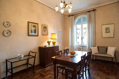 a living room with a table and chairs and a window at Amici di Roma in Rome