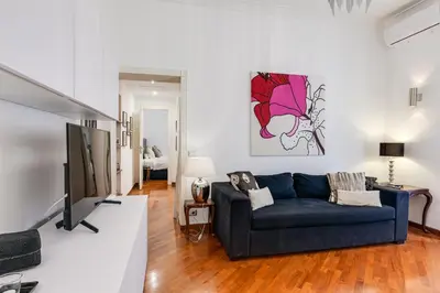 a living room with a blue couch and a tv at S. Cosimato Trastevere in Rome
