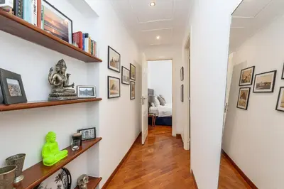 a hallway with wooden floors and white walls with bookshelves at S. Cosimato Trastevere in Rome