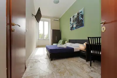 a bedroom with a bed and a chair and a window at Lucky Stars rooms in Rome