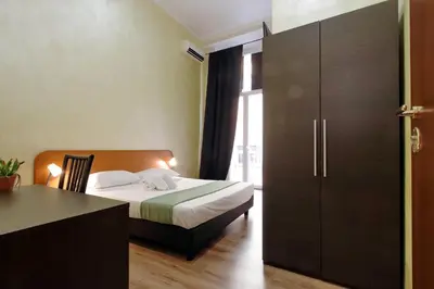 a bedroom with a bed and a desk and a cabinet at Lucky Stars rooms in Rome