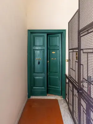a green door in a room with a fence at House Montebello in Rome