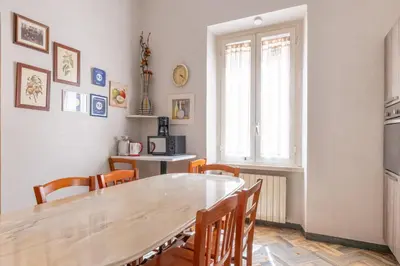 a dining room with a wooden table and chairs at House Montebello in Rome