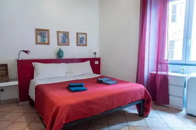 a bedroom with a red bed with two towels on it at fruitroom rome in Rome