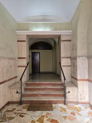 an empty hallway with stairs in an old building at fruitroom rome in Rome