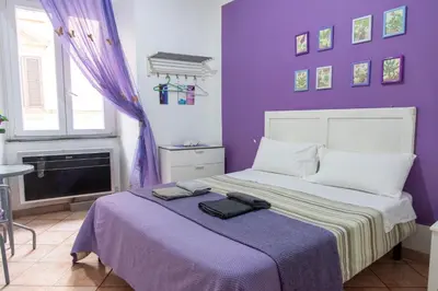 a purple bedroom with a bed with a purple wall at fruitroom rome in Rome