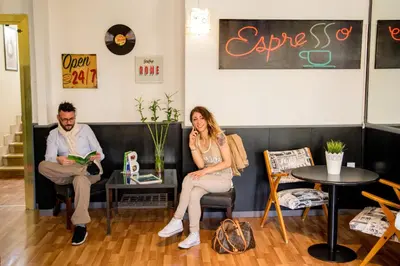 a man and a woman sitting in chairs in a room at Radio Hotel in Rome