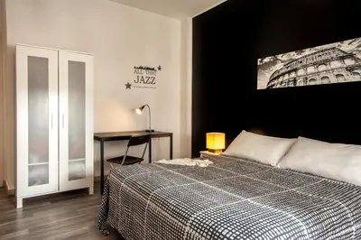 a bedroom with a bed and a desk with a lamp at Radio Hotel in Rome