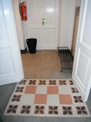 a hallway with a checkered floor in front of a door at Domi Aloisii in Rome