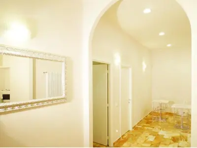 a white room with a mirror and a hallway at Manila Inn in Rome
