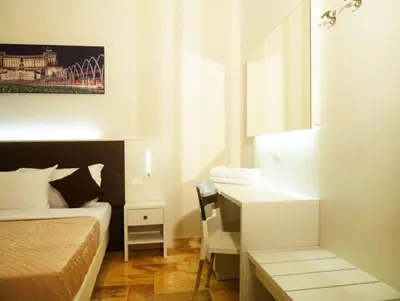 a hotel room with a bed and a desk and a bed and a desk at Manila Inn in Rome