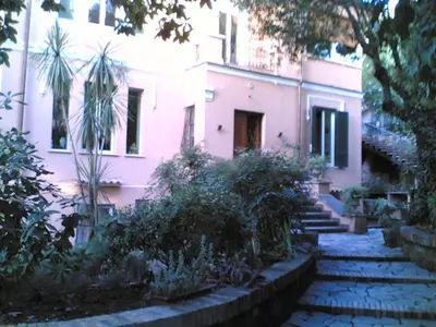 a pink house with stairs in front of it at Villino Corbelli B&B in Rome