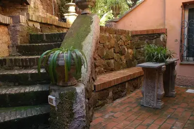 a stone wall with a bench next to a stone staircase at Villino Corbelli B&B in Rome