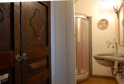 a bathroom with a wooden door and a sink at Villino Corbelli B&B in Rome